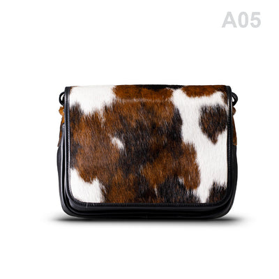 woody Klara Damen-Handtasche aus Natur-Fell in Schwarz, getragen am Arm